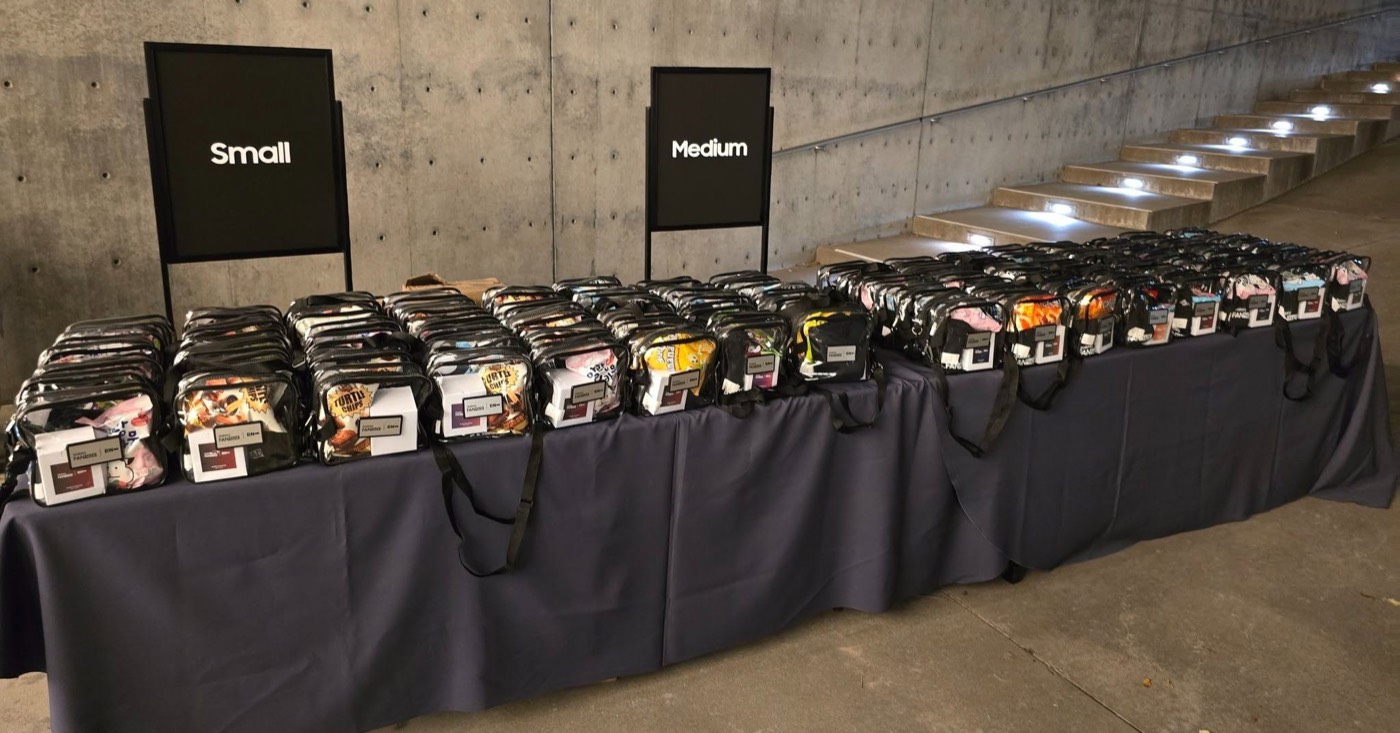 An organized corporate event gift-bag and swag table sorted by size